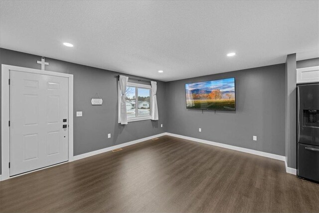 foyer entrance featuring a textured ceiling and dark hardwood / wood-style floors