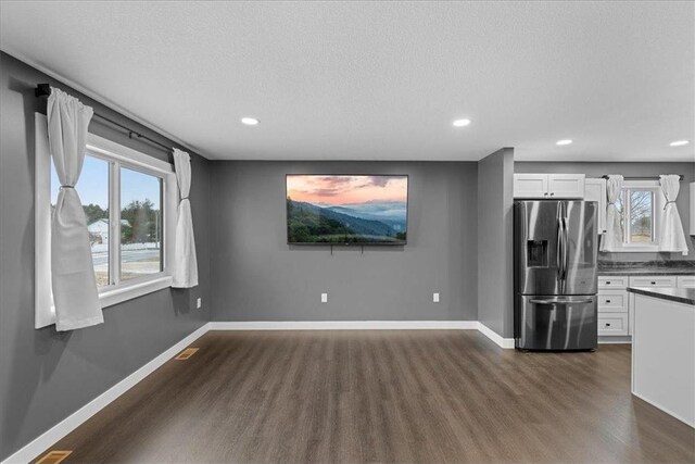 interior space with white cabinets, stainless steel fridge with ice dispenser, and dark hardwood / wood-style flooring