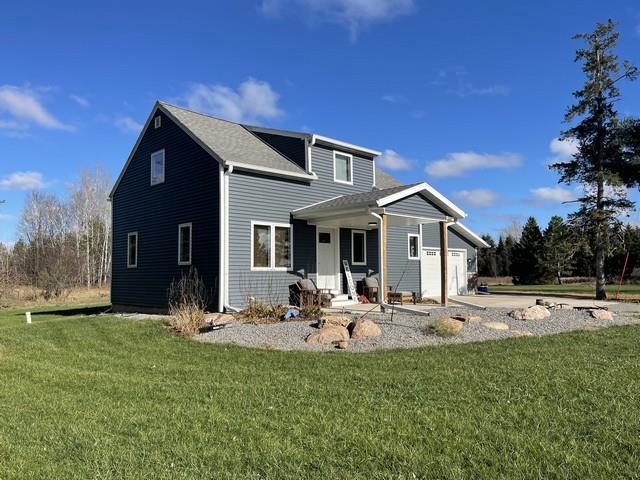 back of house featuring a yard and a garage