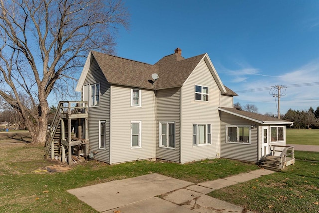 rear view of property featuring a lawn and a patio