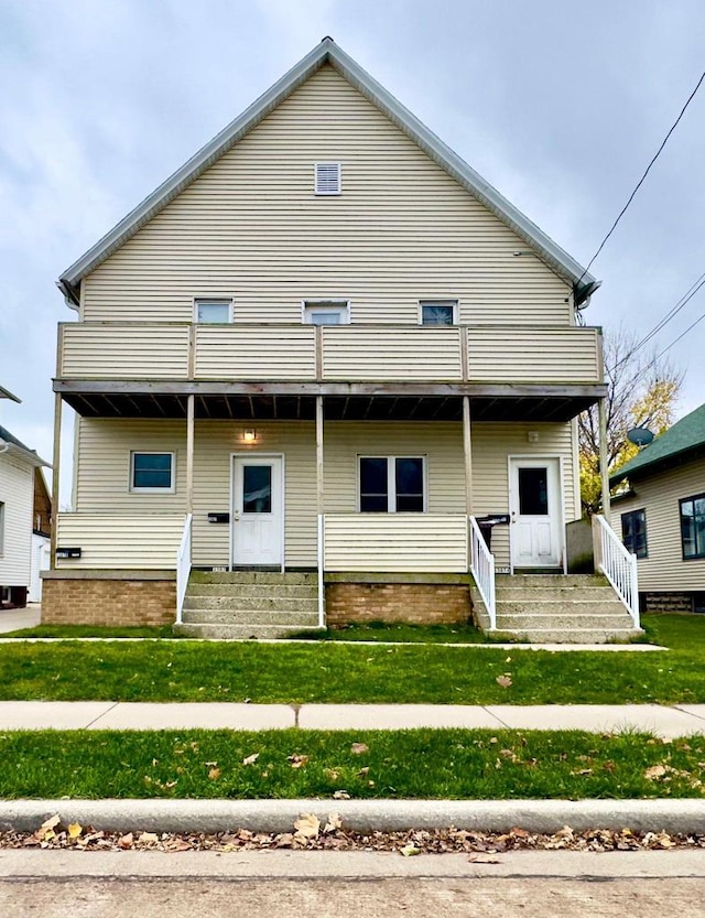 rear view of property featuring a lawn