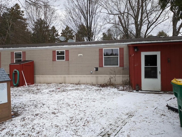 view of snow covered back of property