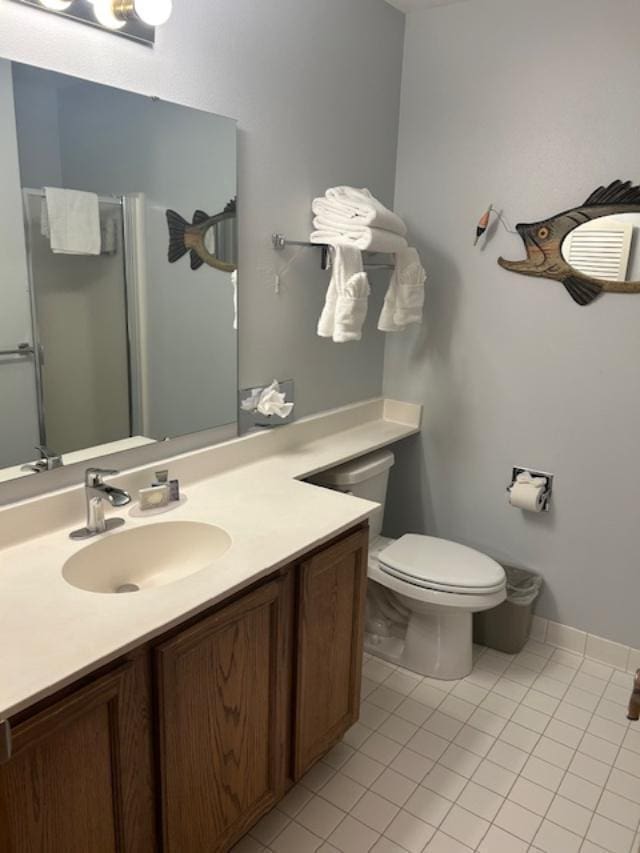 bathroom featuring tile patterned flooring, vanity, toilet, and walk in shower