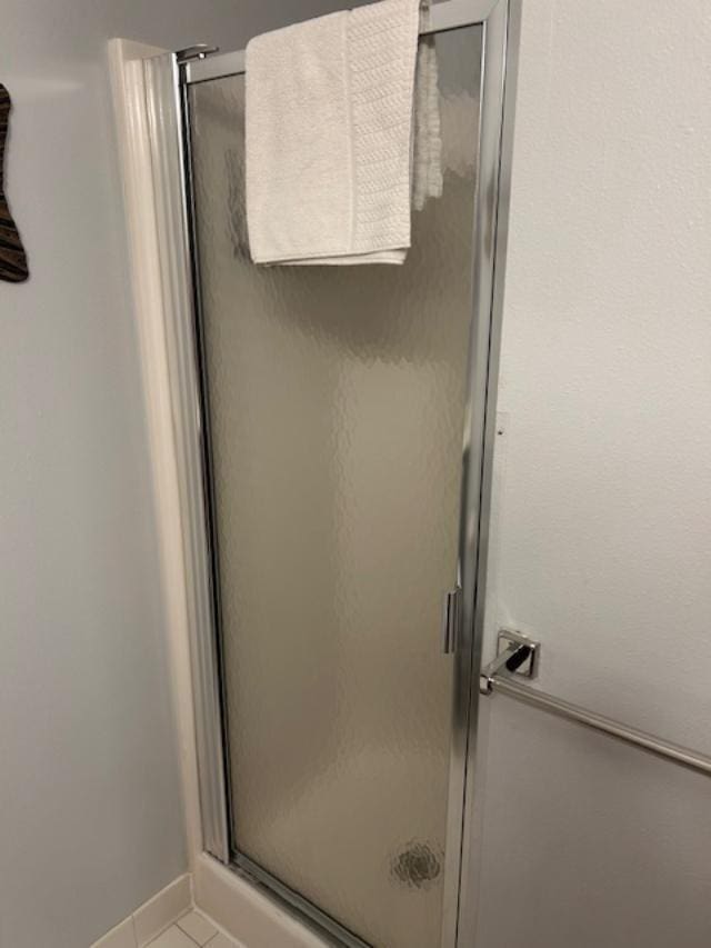 bathroom featuring tile patterned flooring and an enclosed shower