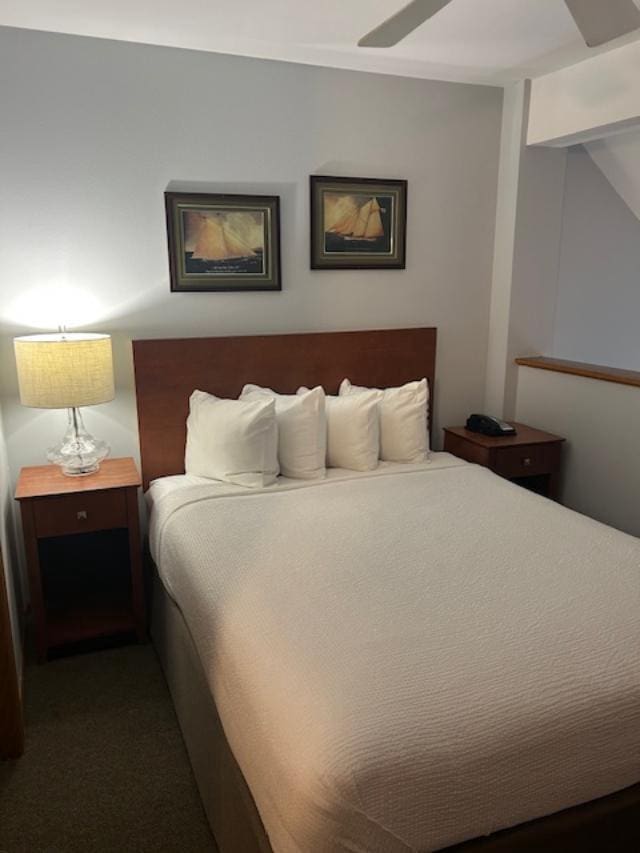 bedroom featuring ceiling fan and dark carpet