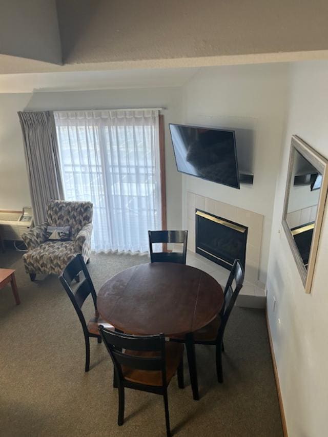 dining space featuring carpet flooring and a fireplace