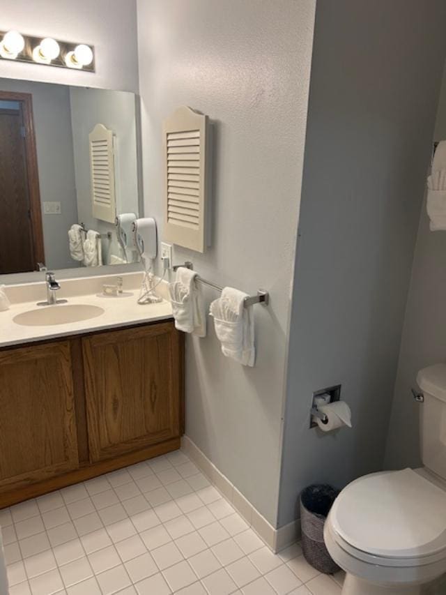 bathroom featuring tile patterned flooring, vanity, and toilet