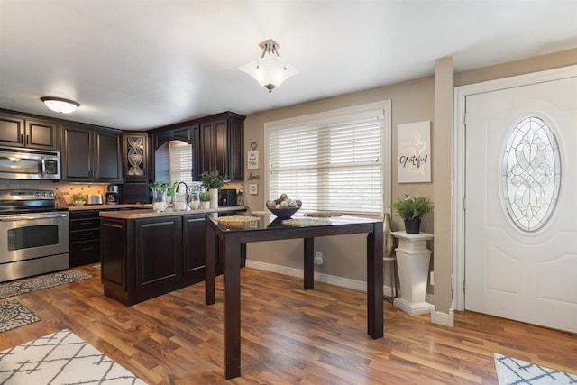 kitchen featuring dark brown cabinets, dark hardwood / wood-style flooring, and appliances with stainless steel finishes