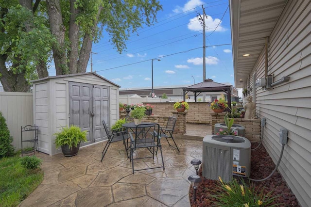 view of patio with a gazebo, a storage unit, and central AC