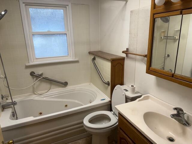 full bathroom with toilet, vanity, and tiled shower / bath