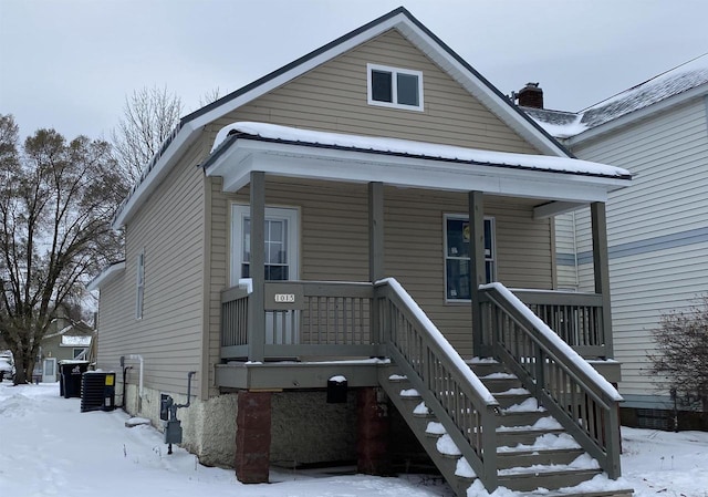 bungalow-style home with covered porch and central air condition unit