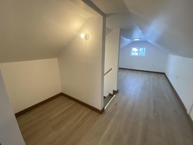 bonus room with wood-type flooring and vaulted ceiling