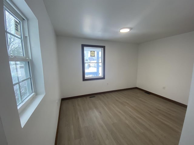 spare room with hardwood / wood-style flooring and a healthy amount of sunlight