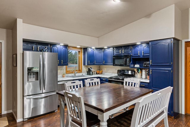 kitchen with sink, black appliances, vaulted ceiling, and blue cabinets