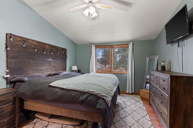 bedroom with light hardwood / wood-style floors, ceiling fan, and lofted ceiling