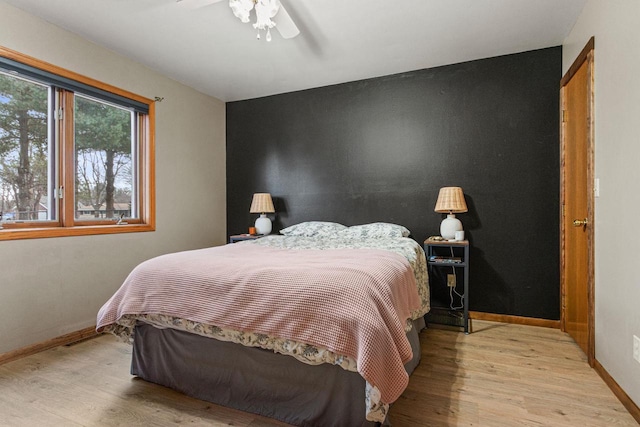 bedroom with ceiling fan and light wood-type flooring