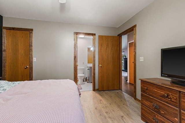 bedroom with light wood-type flooring and connected bathroom