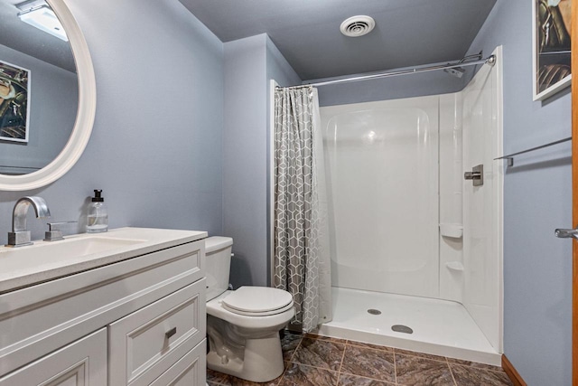 bathroom with curtained shower, vanity, and toilet