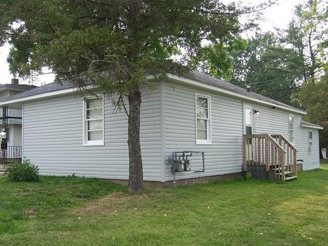 view of side of home with a lawn