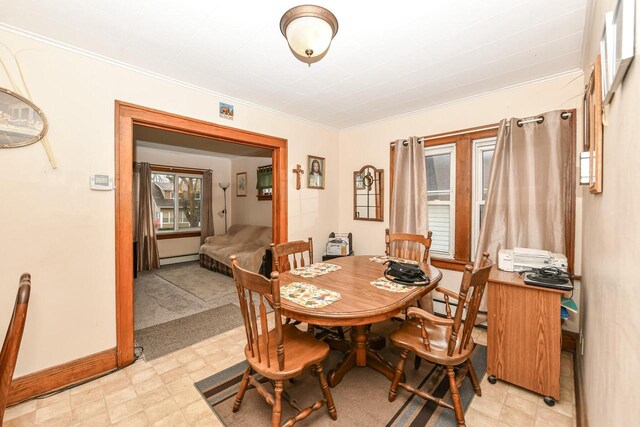 dining space with baseboard heating and crown molding