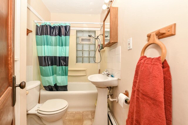 full bathroom featuring sink, shower / bath combo, and toilet