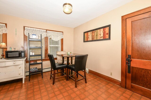 dining area with tile patterned flooring and a baseboard heating unit