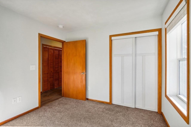 unfurnished bedroom featuring light colored carpet and a closet