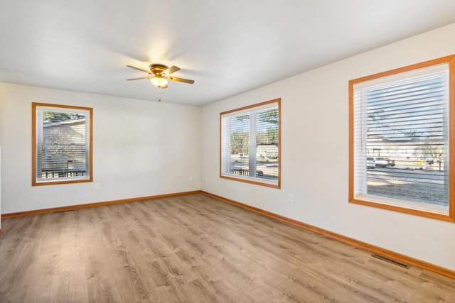 unfurnished room with light hardwood / wood-style floors, ceiling fan, and a healthy amount of sunlight