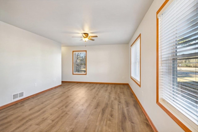 spare room with a wealth of natural light, light hardwood / wood-style flooring, and ceiling fan