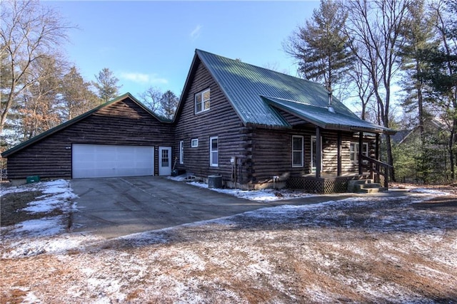 view of side of home featuring central air condition unit and a garage