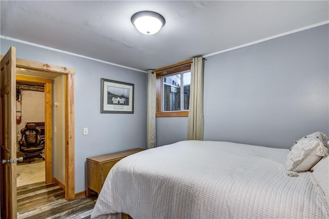 bedroom featuring dark hardwood / wood-style floors and crown molding