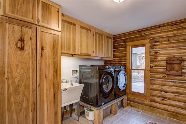 laundry room with rustic walls, separate washer and dryer, and cabinets