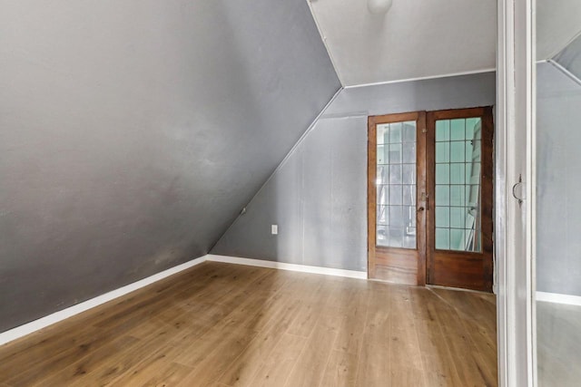 additional living space featuring hardwood / wood-style floors and lofted ceiling