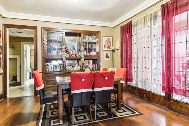 dining space with dark hardwood / wood-style floors, crown molding, and a healthy amount of sunlight