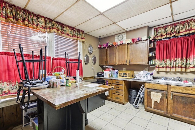 kitchen featuring a drop ceiling and light tile patterned flooring