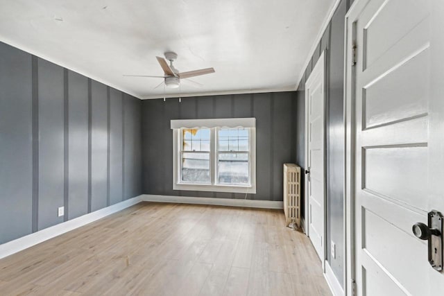 unfurnished room featuring light hardwood / wood-style floors, radiator, and ceiling fan