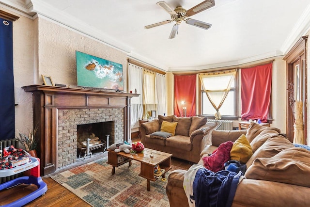 living room with a fireplace, ceiling fan, hardwood / wood-style floors, and ornamental molding