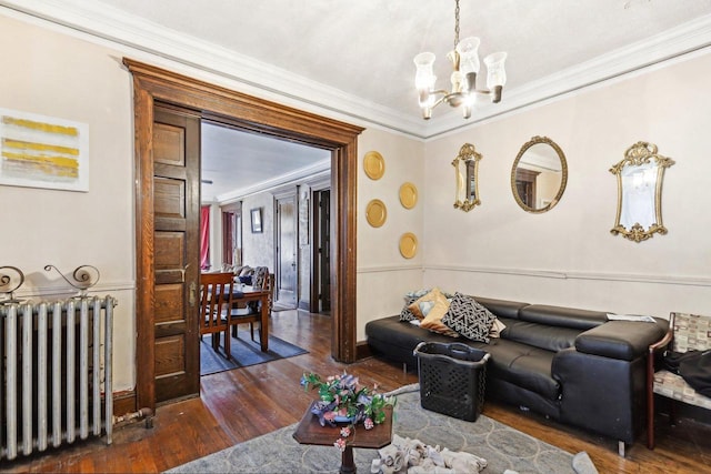 living room featuring radiator, a chandelier, dark hardwood / wood-style floors, and ornamental molding