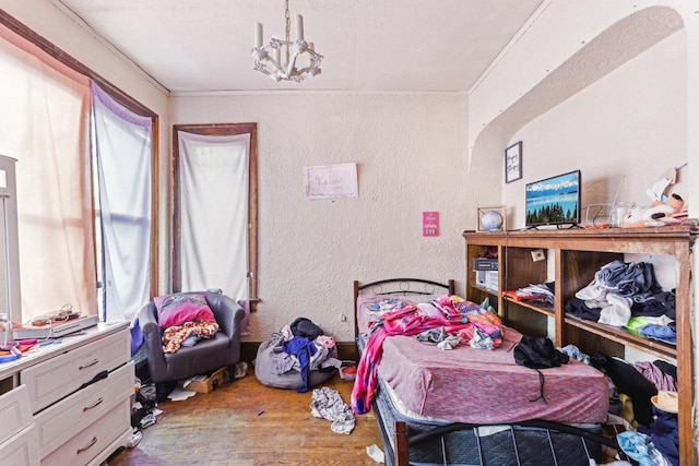 bedroom featuring multiple windows, crown molding, hardwood / wood-style floors, and a chandelier