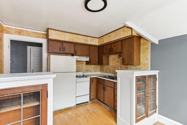 kitchen with white appliances, light hardwood / wood-style flooring, and sink