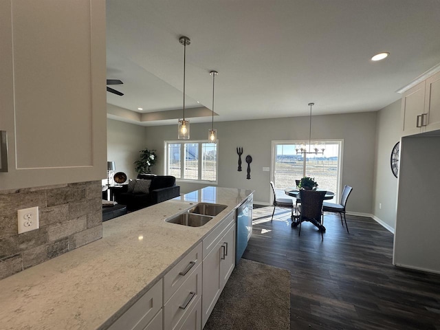 kitchen featuring ceiling fan with notable chandelier, light stone counters, decorative light fixtures, dark hardwood / wood-style flooring, and white cabinetry