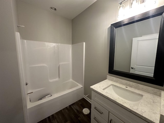 bathroom with hardwood / wood-style flooring, vanity, and shower / tub combination