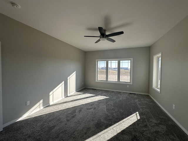 unfurnished room featuring dark carpet and ceiling fan