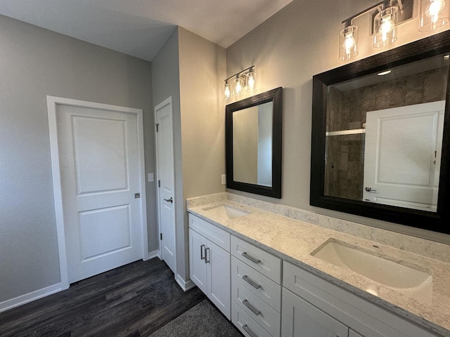 bathroom with walk in shower, vanity, and hardwood / wood-style flooring