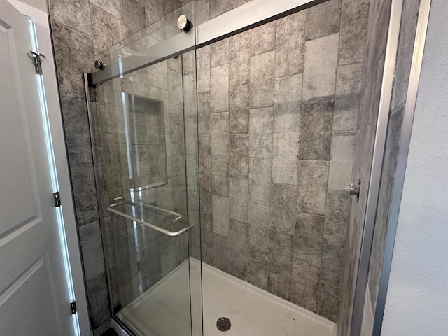 bathroom featuring a shower with door