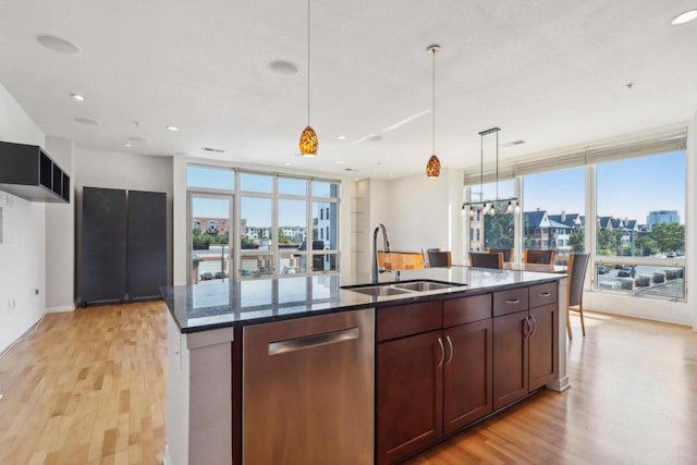 kitchen with dishwasher, a kitchen island with sink, sink, and a wealth of natural light