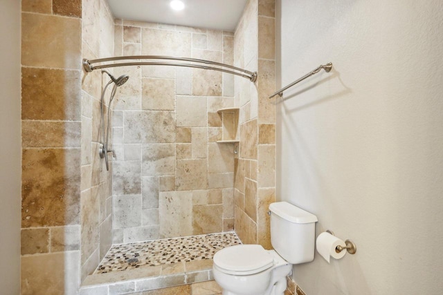 bathroom featuring toilet and tiled shower