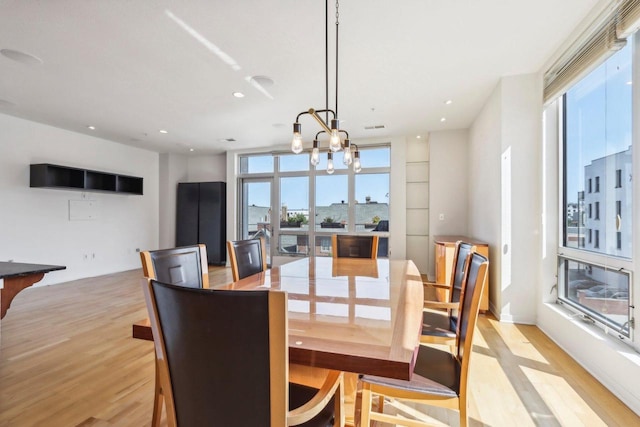 dining room featuring light wood-type flooring and a chandelier