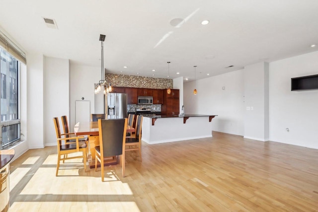 dining space with light wood-type flooring and sink