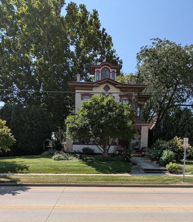 italianate-style house featuring a front lawn